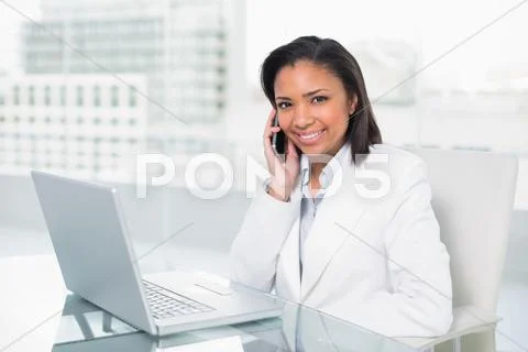 Stylish young dark haired businesswoman making a phone call Stock Photos
