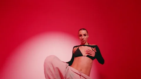 Stylish young female dancer performing hip hop dance, red color wall in studio Stock Footage 277534633
