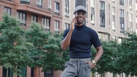 Stylish young happy man talking on phone standing on city street. Handsome Stock Footage 255201921