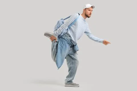 Stylish young man in cap with backpack on light background Stock Photos