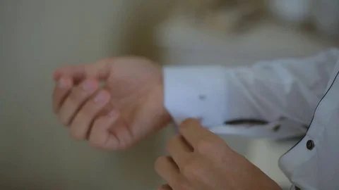 A stylish young man fastens his shirt and prepares for an go out Video stock 80732632