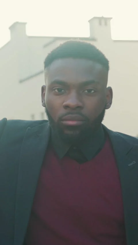 A Stylish Young Man Gazing Thoughtfully Outdoors in the Soft, Warm Glow of Stock Footage 304491808