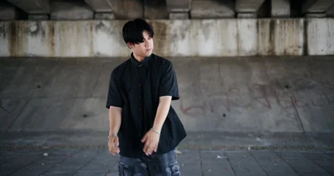 A stylish young man performs a freestyle dance under a footbridge in the city. 库存影片 319637303