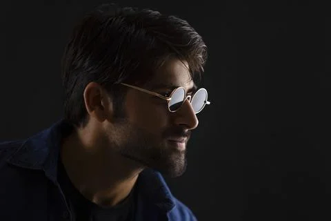 A STYLISH YOUNG MAN POSING WHILE LOOKING AWAY Stock Photos