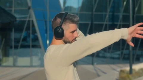 Stylish young man in profile view listening to music outdoors Stock Footage 317554721