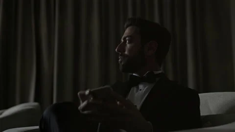 Stylish Young Man Sitting On Sofa With Cellphone In Hands. Man In Suit And White Vídeos de archivo 153707835
