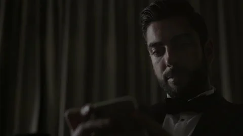 Stylish Young Man Sitting On Sofa With Cellphone In Hands. Man In Suit And White Stock Footage 153709275