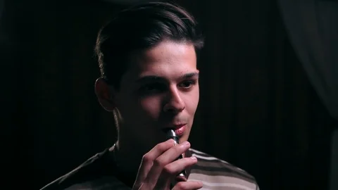 Stylish young man vaping in the room at night, close up Stock Footage 99050693