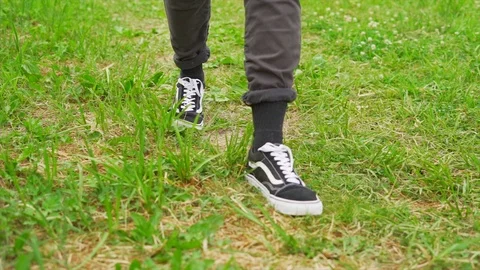Stylish young man walking on the grass with sneakers Stock Footage 91230865