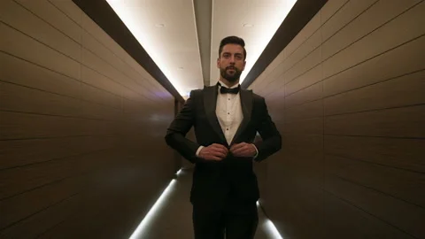 Stylish Young Man Walks Down The Hotel Corridor. He Is Dressed In Suit. Man Stock Footage 153714131