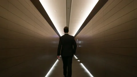 Stylish Young Man Walks Down The Hotel Corridor. He Is Dressed In Suit. Man Stockbeeldmateriaal 153714438