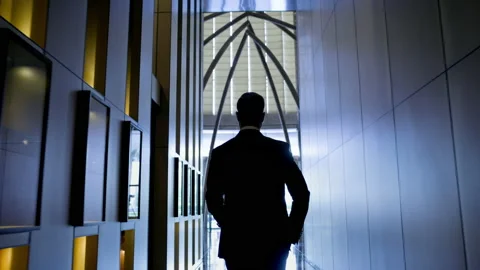 Stylish Young Man Walks Down The Hotel Corridor. He Is Dressed In Suit. View Vídeos de archivo 153715498