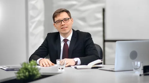 Stylish young office worker in glasses posing at workplace medium shot on red Video stock 123456900