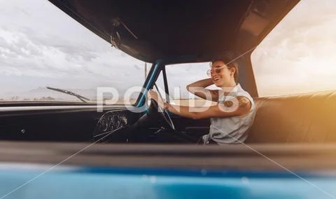 Stylish young woman on road trip driving a car Stock Photos