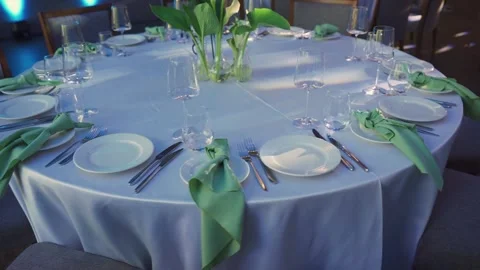 Stylishly decorated, elegantly set round table with cutlery, dishes, crystal Stock Footage 312768122