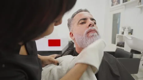 Stylist with african client during beard dyeing in hairdressing salon_2.MOV 스톡 동영상 255797310