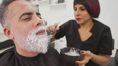 Stylist with african client during beard dyeing in hairdressing salon_4.MOV 스톡 동영상 255797333