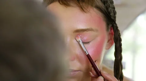 Stylist to apply makeup on the model's face Video stock 68844319