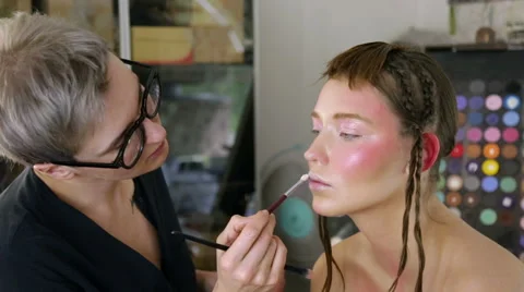 Stylist to apply makeup on the model's face Video stock 68851497