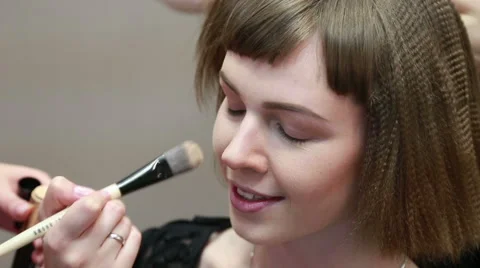 Stylist applying make up to a beautiful young girl Stock Footage 48622132