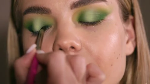 The stylist applying make-up to a young model Stock Footage 229952557