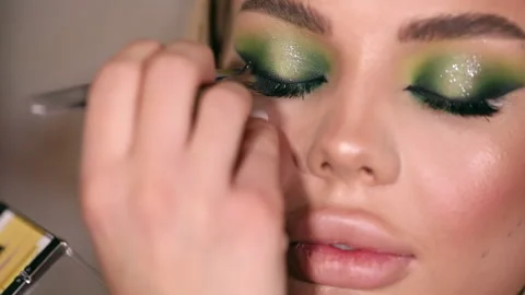 The stylist applying make-up to a young model Stock Footage 229952968