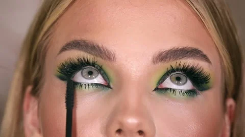 The stylist applying make-up to a young model Stock Footage 229953116