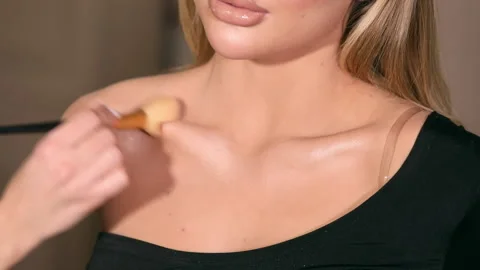 The stylist applying make-up to a young model Stock Footage 229953474