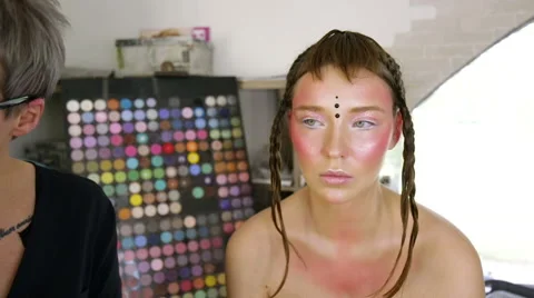 Stylist attach decorative elements to the model's face Stock Footage 68851632
