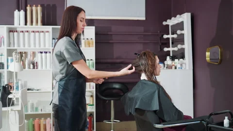 Stylist carefully preparing client in modern salon environment, vibrant salon Stock Footage 321654215