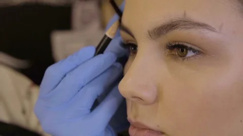 Stylist does beautiful eyebrows to the young beautiful woman. Beauty shop. Close 스톡 동영상 73943597