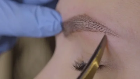 Stylist does beautiful eyebrows to the young beautiful woman. Beauty shop. Close 스톡 동영상 73944515
