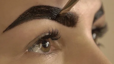 Stylist does beautiful eyebrows to the young beautiful woman. Beauty shop. Close 스톡 동영상 73944730