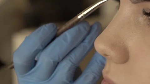 Stylist does beautiful eyebrows to the young beautiful woman. Beauty shop. Close 스톡 동영상 73944950