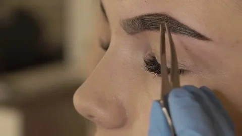 Stylist does beautiful eyebrows to the young beautiful woman. Beauty shop. Close 스톡 동영상 73945047