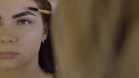 Stylist does beautiful eyebrows to the young beautiful woman. Beauty shop. Close 스톡 동영상 73953087