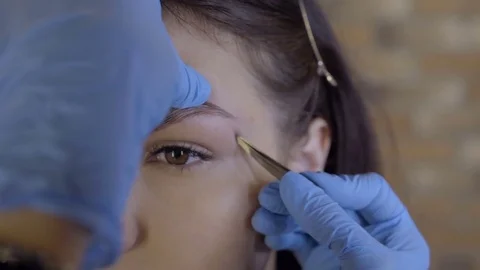 Stylist does beautiful eyebrows to the young beautiful woman. Beauty shop. Close 스톡 동영상 73954743