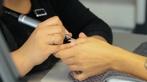Stylist filing a client's nails by doing her manicure Stock Footage 252135596