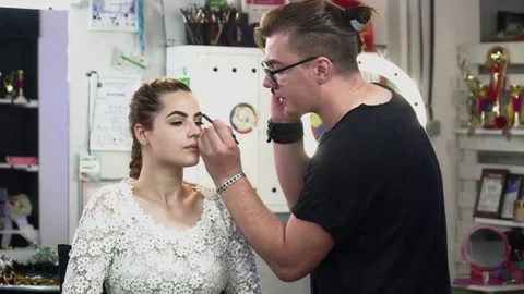 Stylist making makeup for a beautiful bride Stock Footage 77237414