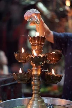 Stylized antique style three-level oil lamp with an open flame of wicks in cu Stock Photos