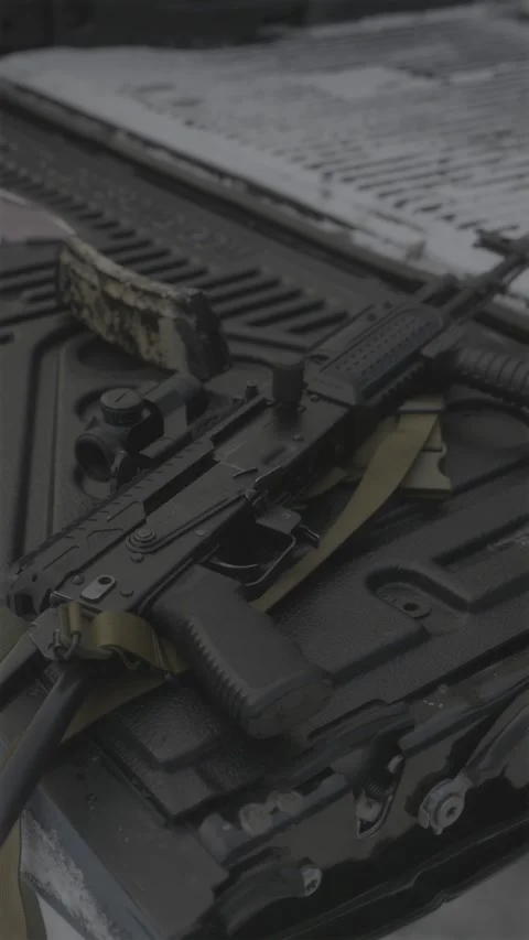 Stylized modernized AK rifle with scope on textured black pickup tailgate d.. Stock Footage 333612810