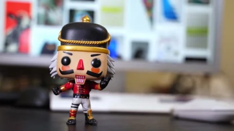 Stylized Nutcracker Toy on Desk with Blurred Monitor Stock Footage 312374064