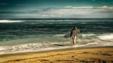 Stylized surfer on beach, long exposure Stock Photos