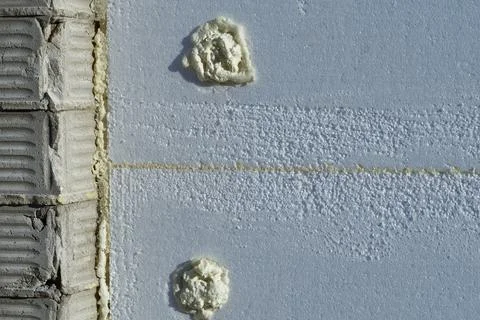 Styrofoam insulation panel with adhesive,brick wall,installation Stock Photos