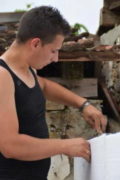 Styrofoam insulation, Young man doing repair works on the wall in the backyard Foto stock
