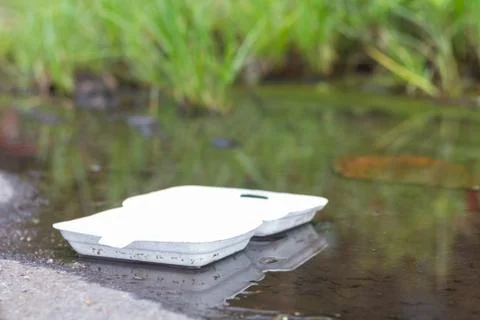 Styrofoam waste floating on riverbank, Object background of ecological harm. Stock Photos