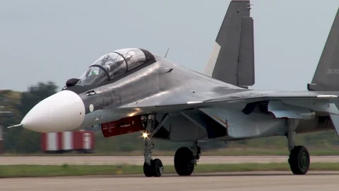 Su-30SM aircraft with thrust vectoring quickly taxis in parking lot near runway. Stock Footage 106799946