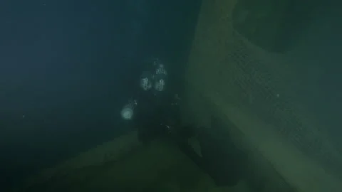 Sub approaches bow of wreck Adernò wrapped by net illuminating turning around Stock Footage 228060911