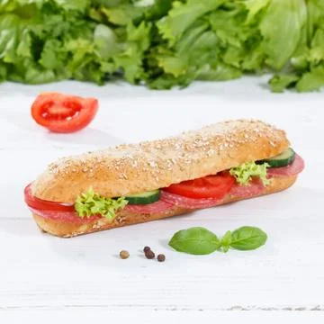 Sub sandwich whole grain grains baguette with salami ham square on wooden boa Stock Photos