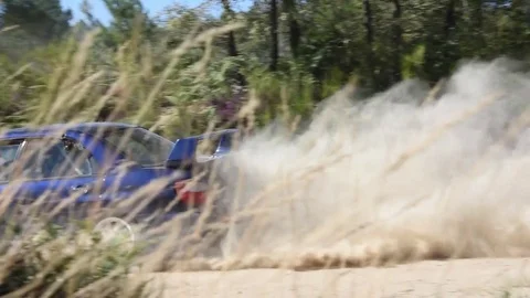 Subaru rally car accelerating into a corner on a dirt race track Stock Footage 74397851